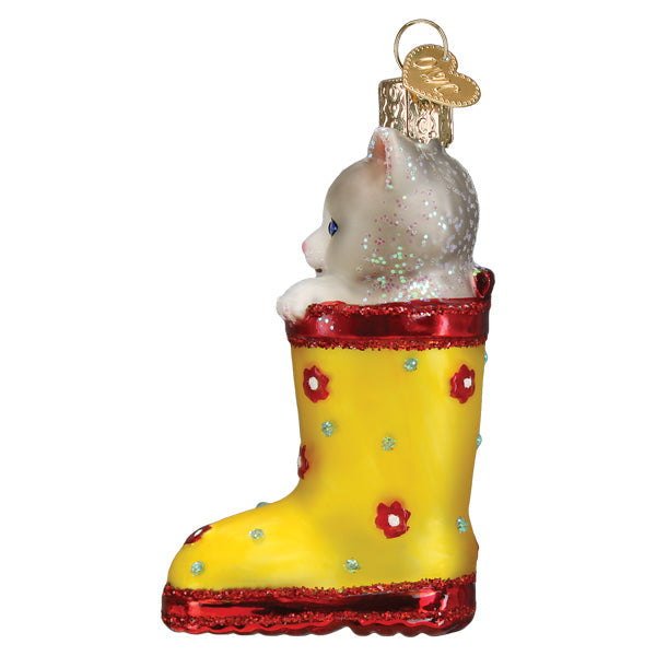 Glass Christmas ornament featuring a grey kitten sitting inside a yellow floral rain boot.