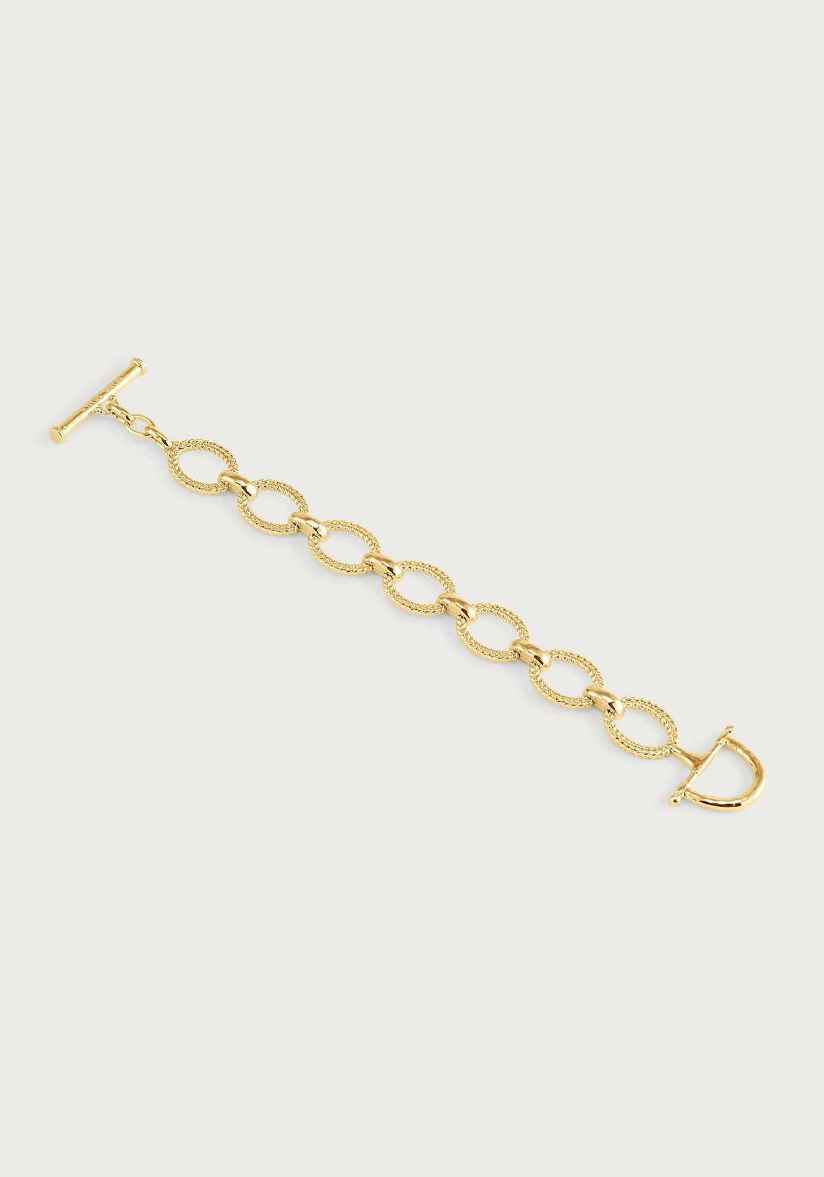 Gold Cheval Chain Bracelet with braided oval links and an equestrian horse bit toggle clasp.