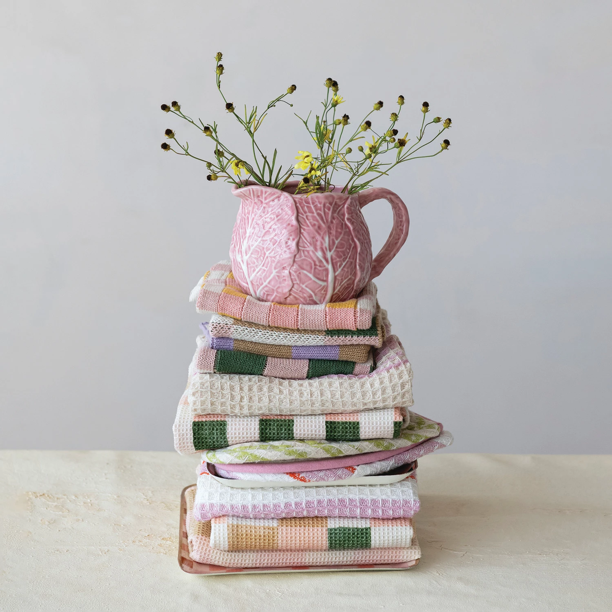 Pink stoneware creamer shaped like a cabbage with green leaf accents.