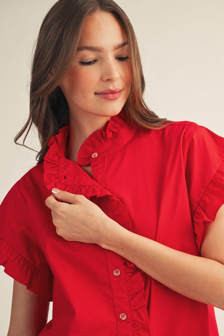 Close-up of a woman wearing a red Elise Ruffled Detail Woven Top with a ruffled collar and buttons.