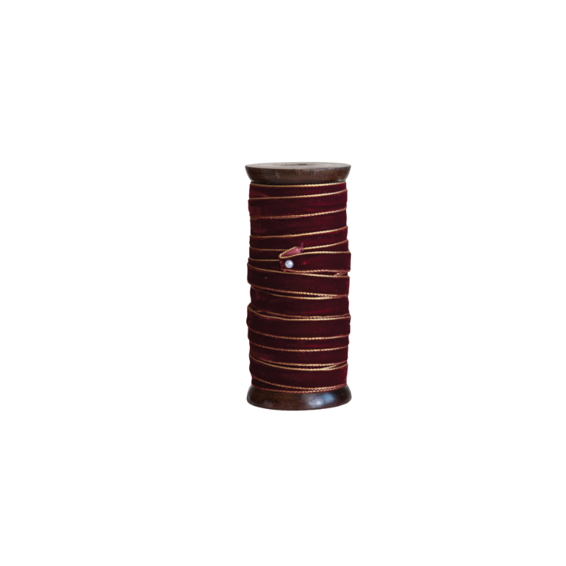 10 yards of burgundy velvet ribbon with gold metallic edges wrapped around a dark wood spool.