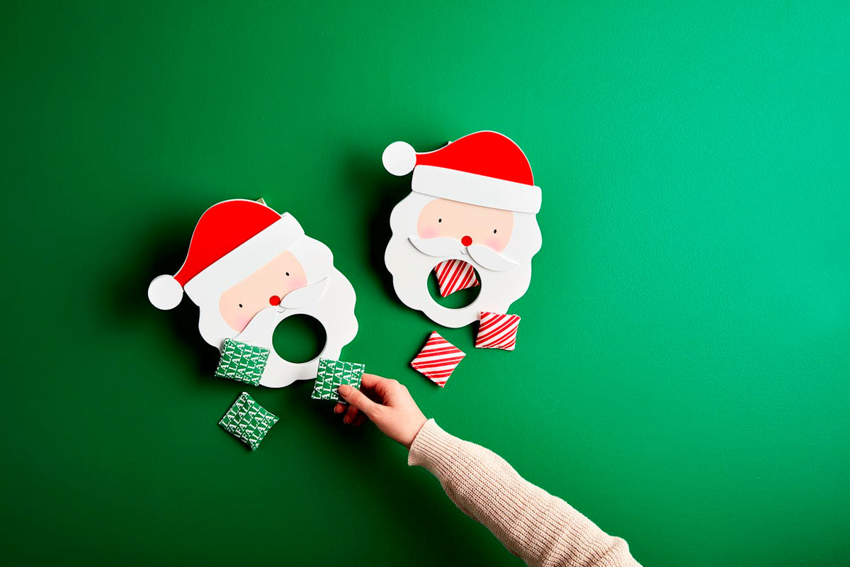 Santa Bag Toss Game with two wooden Santa goals and red and green striped bean bags.