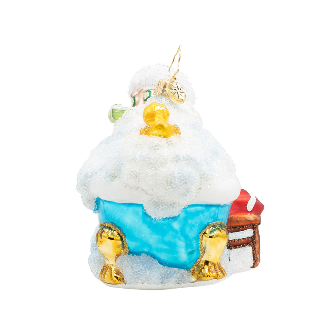 Glass Christmas ornament of Santa Claus relaxing in a blue clawfoot tub filled with white bubbles.