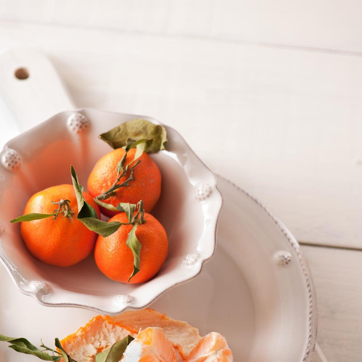 Whitewash ceramic berry bowl with ruffled fluting, scalloped edge, and painted berries.