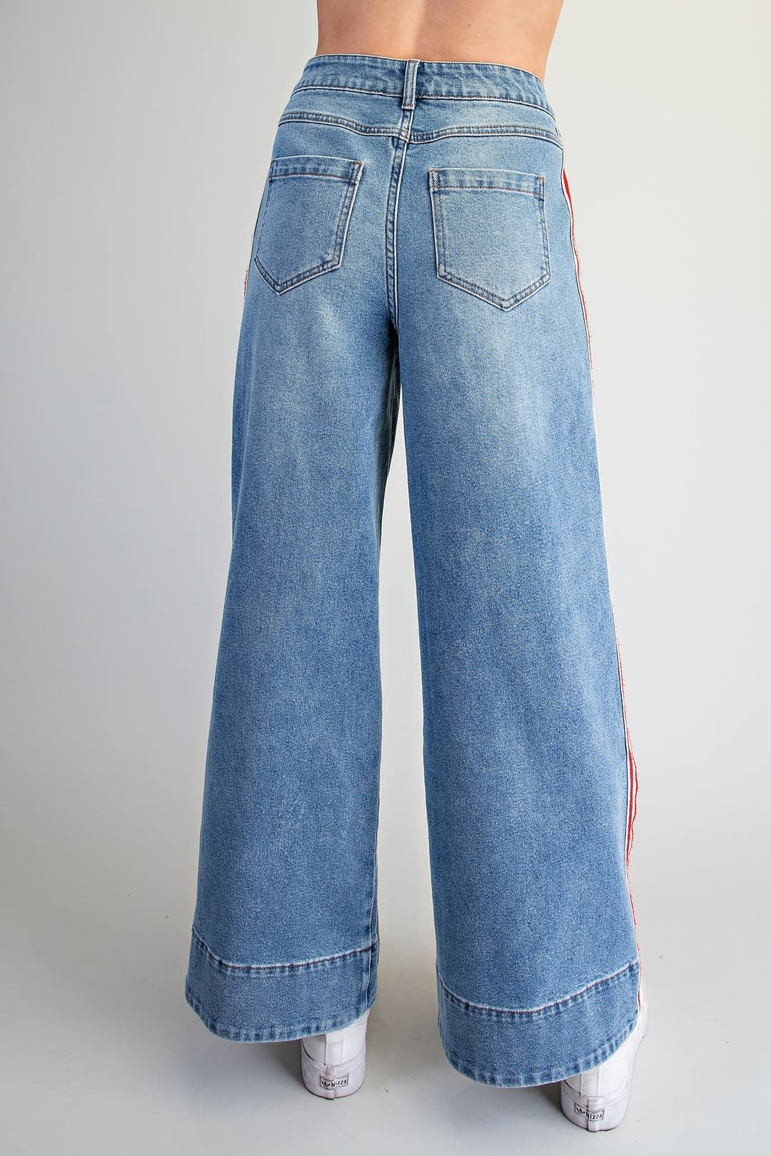 Back view of Amelia high-waisted wide leg denim pants with red and white side stripes.