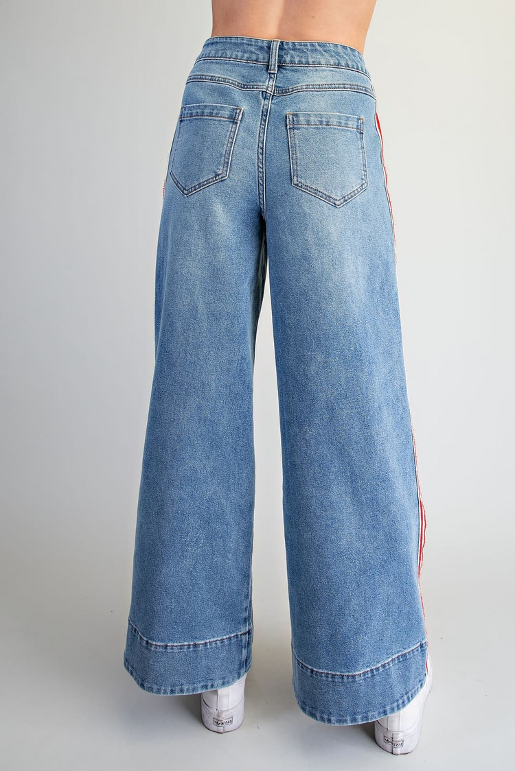Back view of Amelia high-waisted wide leg denim pants with red and white side stripes.