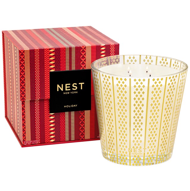 Nest New York Holiday scented candle in a glass jar with gold diamond pattern, next to its red and gold patterned box.