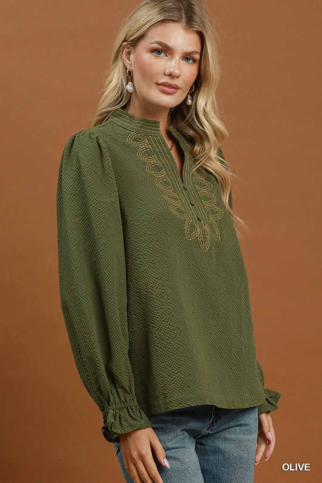Olive green textured blouse with gold neck embroidery, puff sleeves, and ruffled cuffs.