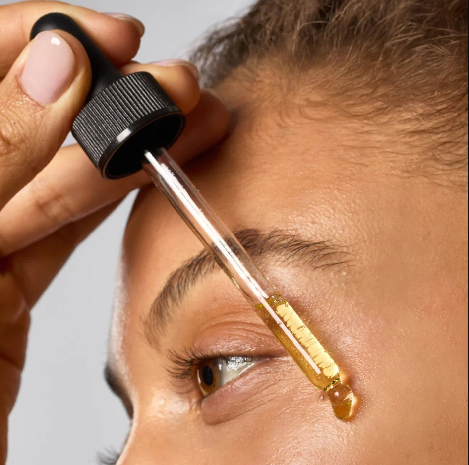 Hydrating Dermaplane Oil in a clear bottle with white liquid inside.