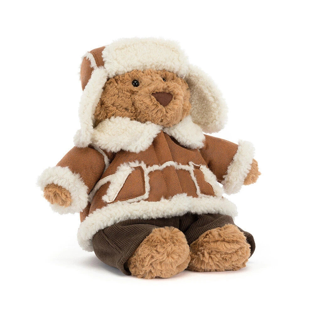 Bartholomew Bear plush toy wearing a brown alpine coat with white faux-fur trim and a matching hat.
