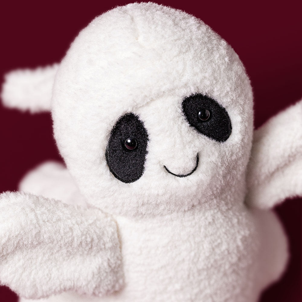 Close-up of Ghost Bob, a white plush ghost toy with black eye patches and a stitched smile.