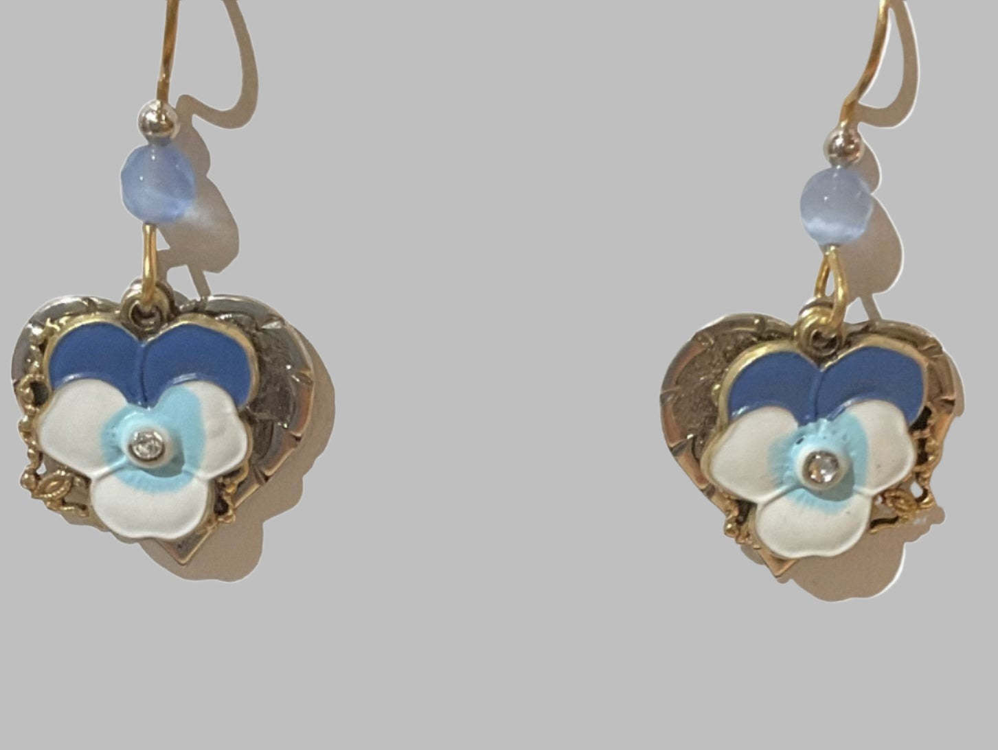 Blue and white flower on silver-tone filigree heart earrings with light blue beads and crystals.
