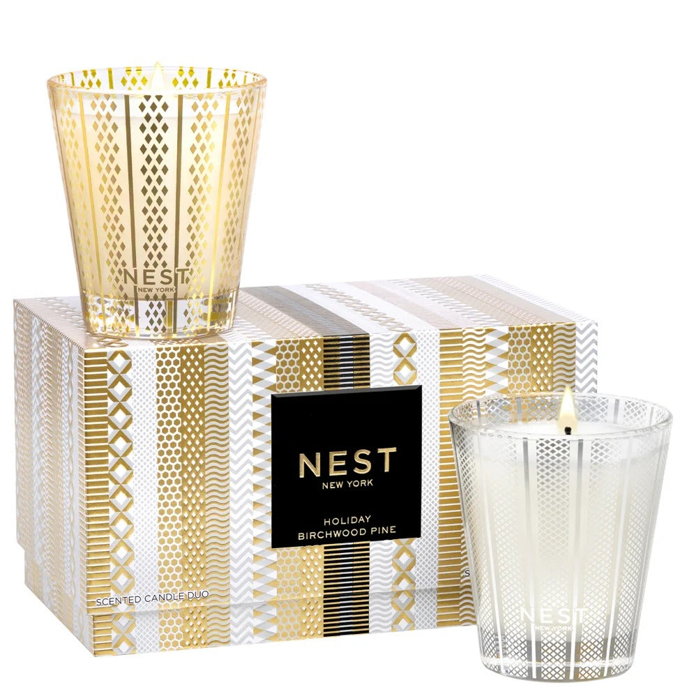 NEST New York Holiday and Birchwood Pine scented candle duo set in decorative glass jars and box.