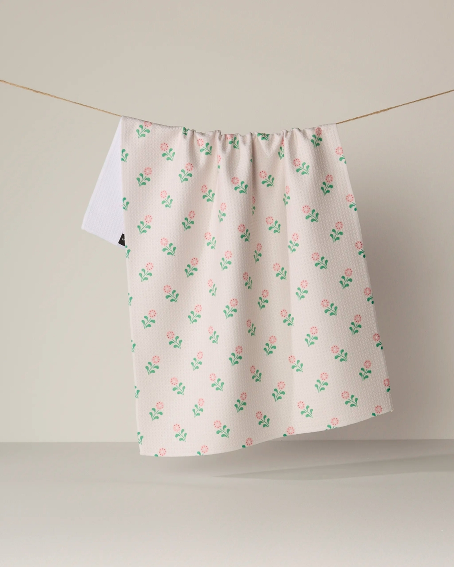 Everyday Tea Towel with a pink floral pattern hanging on a clothesline against a neutral background.