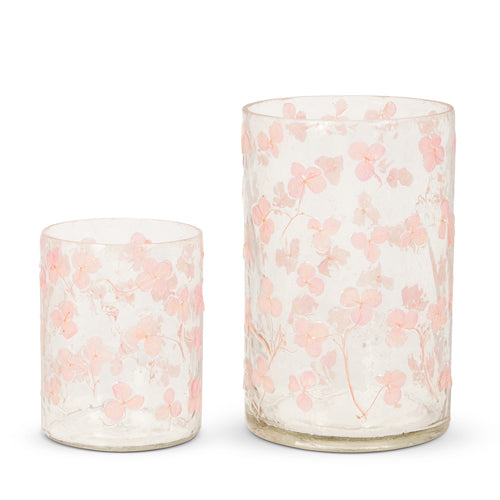 Glass container holding dried floral stems with a clear cylindrical shape.