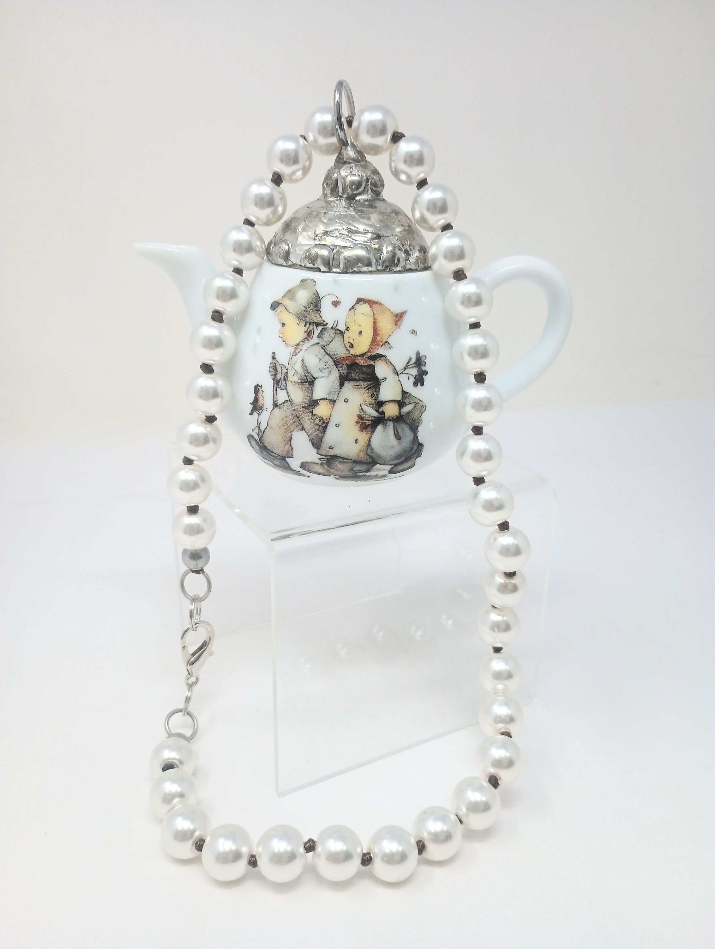 Porcelain teapot charm with M.I. Hummel artwork on an 18-inch pearl necklace