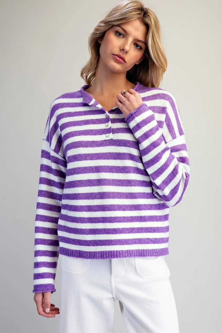 Woman wearing the Eleanor purple and white horizontal striped button-down sweater and white pants.