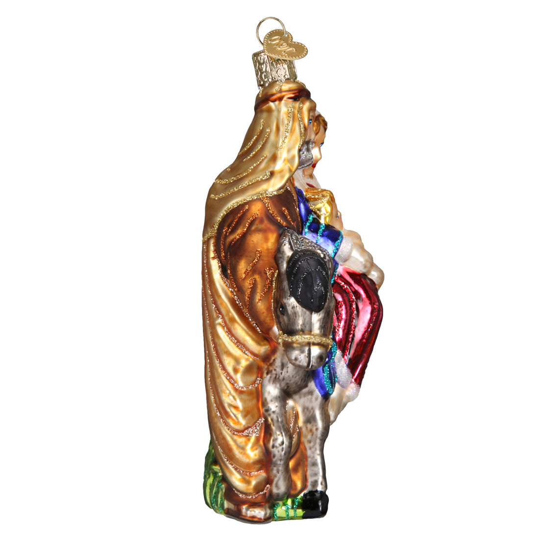 Side view of a glass Flight to Egypt ornament featuring Mary, Joseph, and Jesus on a donkey.