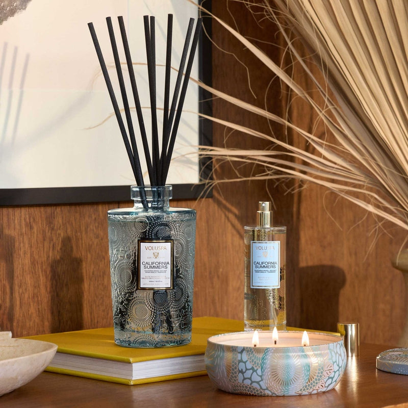 Voluspa California Summers Room Spray bottle next to a matching reed diffuser and lit candle.
