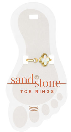 Sand & Stone toe ring with a gold band, a small crystal, and a white clover charm on a foot card.