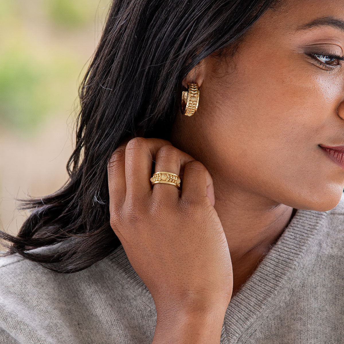 Gold hoop earrings with a berry vine leaf motif