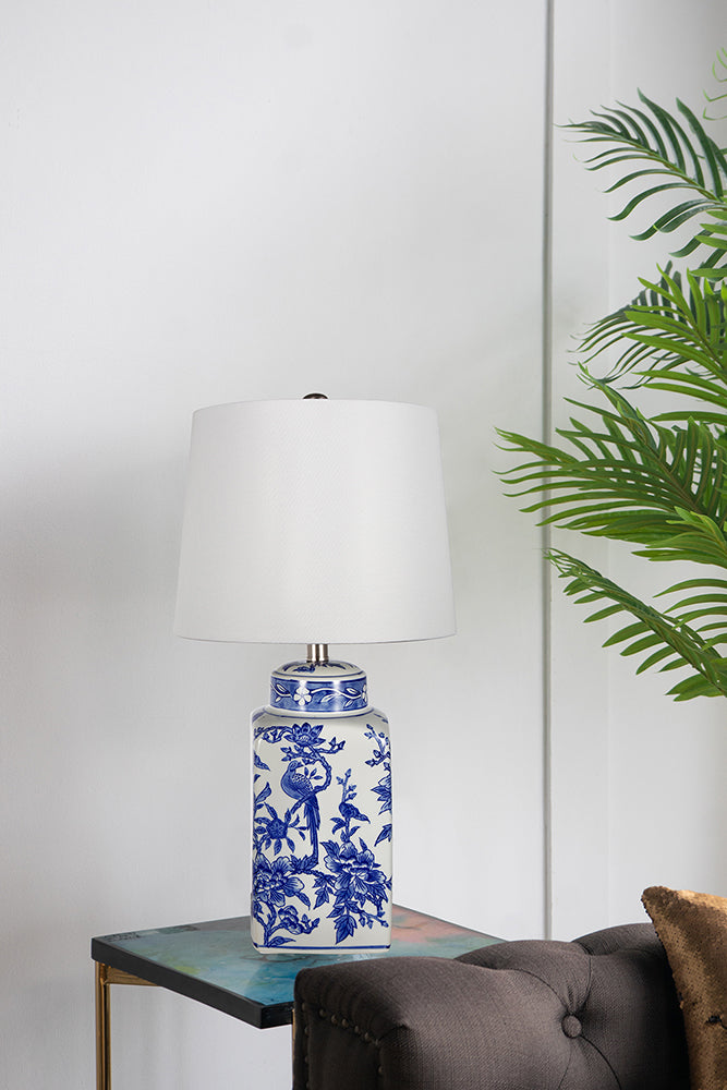 Blue ceramic vase lamp with white linen shade featuring a cylindrical silhouette.