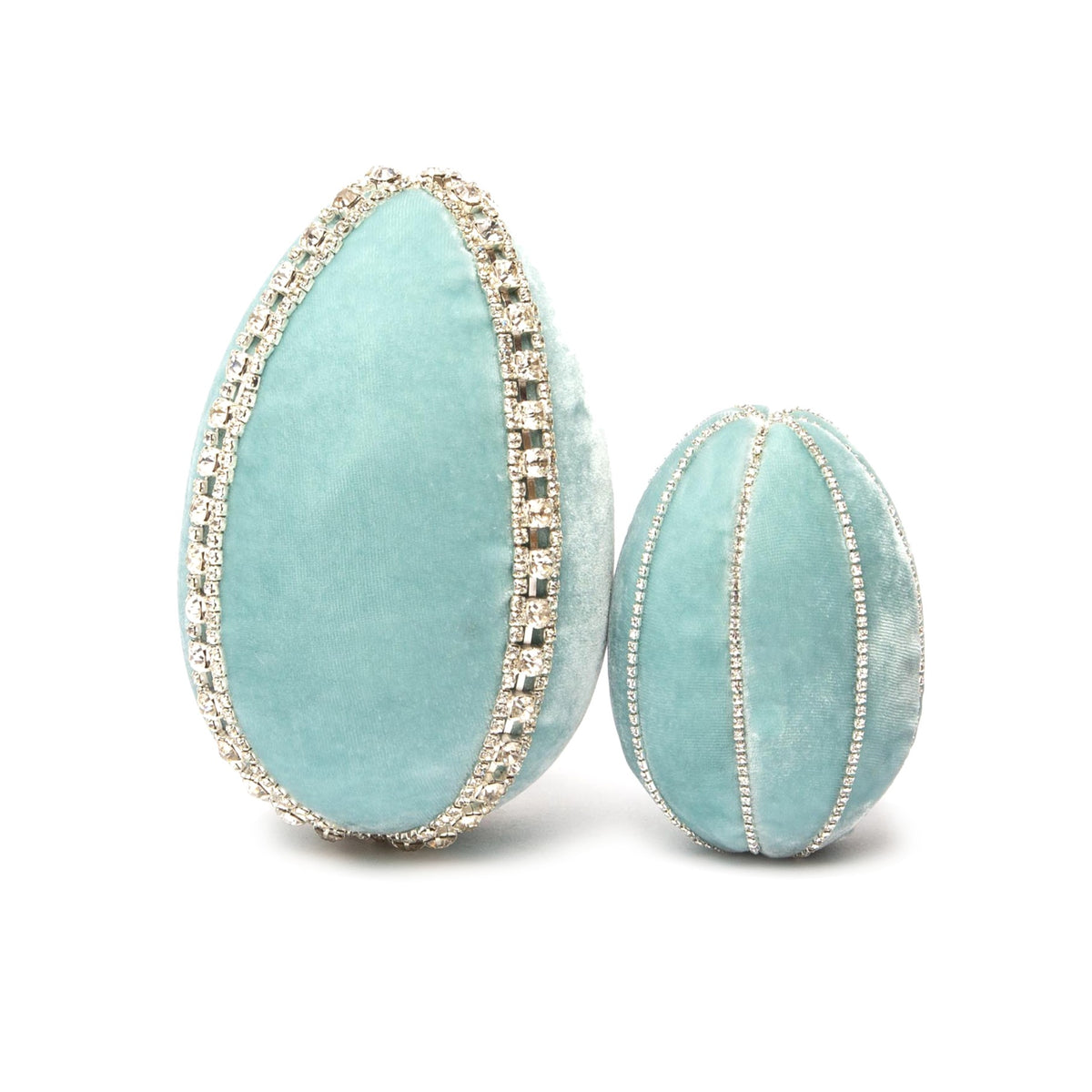 Two teal velvet eggs decorated with sparkling rhinestone trim, one larger than the other.