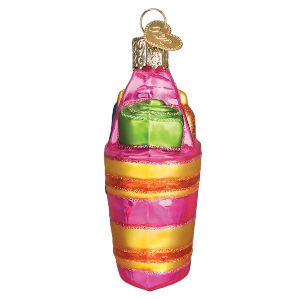 Pink and yellow striped glass beach bag ornament with a green towel and gold heart charm.
