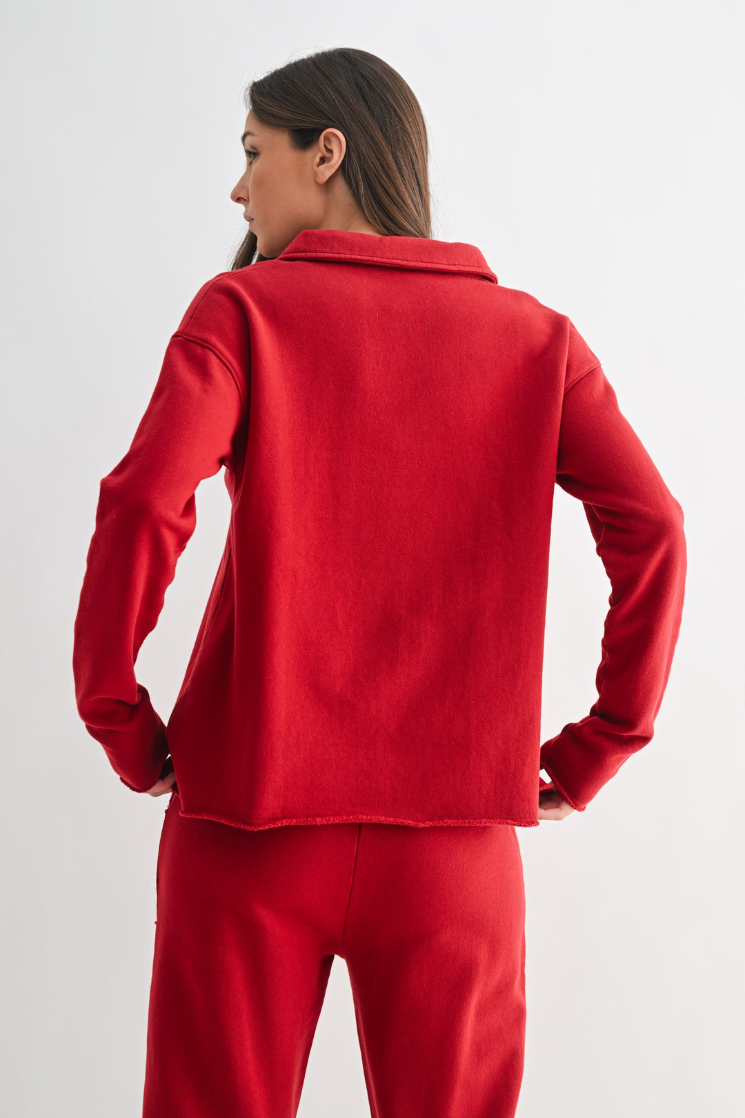 Back view of a woman wearing a red long-sleeve Virginia Malibu Vintage Henley Tee and matching pants