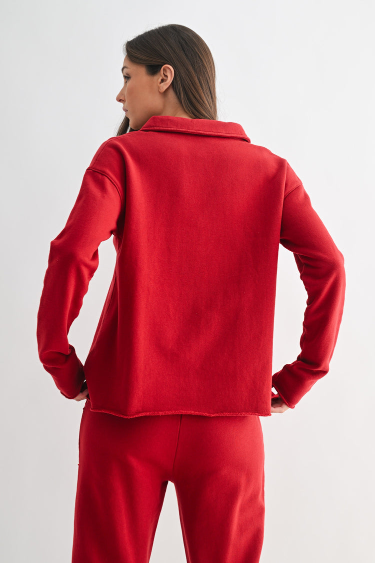 Back view of a woman wearing a red long-sleeve Virginia Malibu Vintage Henley Tee and matching pants