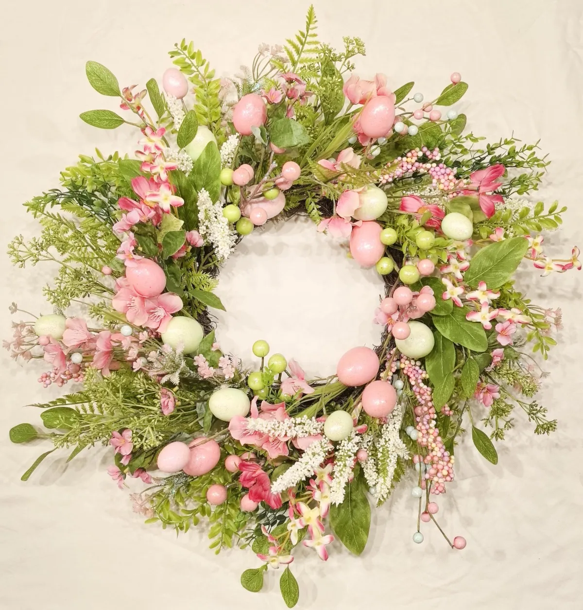 Egg wreath with a circular silhouette featuring pastel egg shapes on a natural woven background.