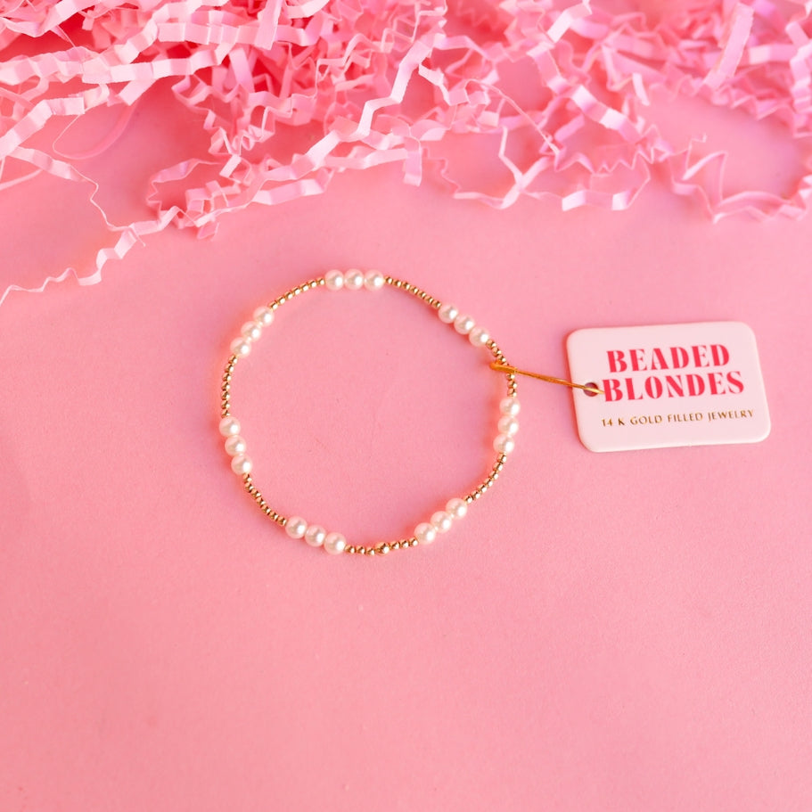 6.75-inch gold pearl bracelet on elastic string with a row of round pearls.