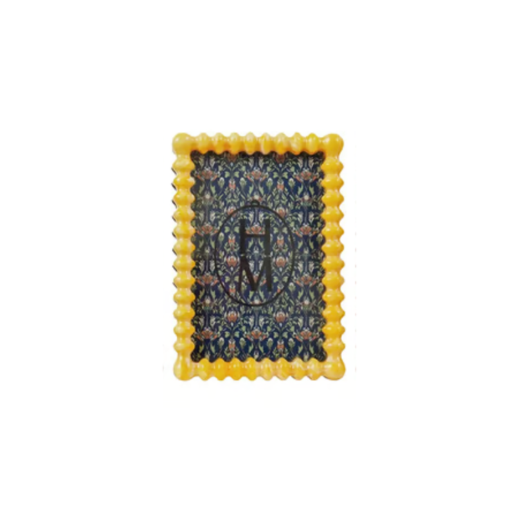 Yellow marbled resin frame with scalloped edges and a dark blue floral pattern insert.