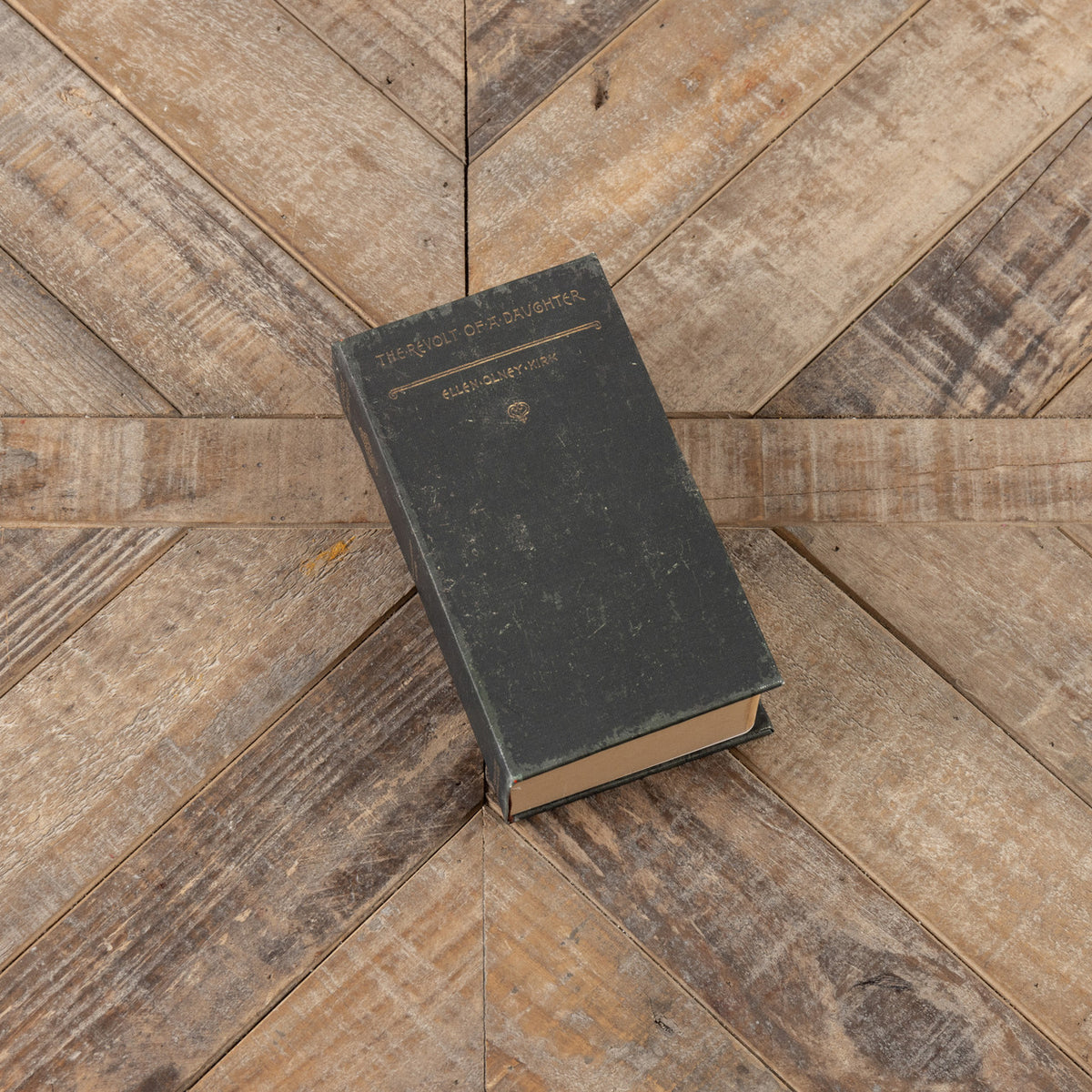 7" The Revolt of a Daughter journal with a dark green cover on a rustic wood background.