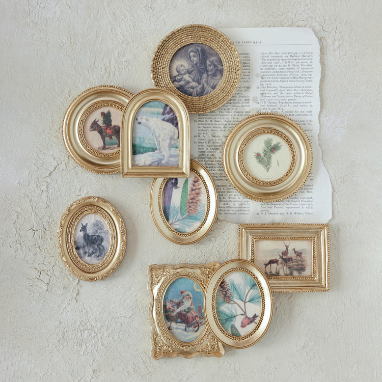 Assorted mini gold-framed vintage seasonal art magnets displayed on a textured wall.