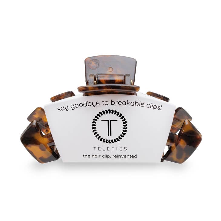 Large tortoise shell hair clip with a rounded silhouette featuring natural brown and amber speckled patterns.