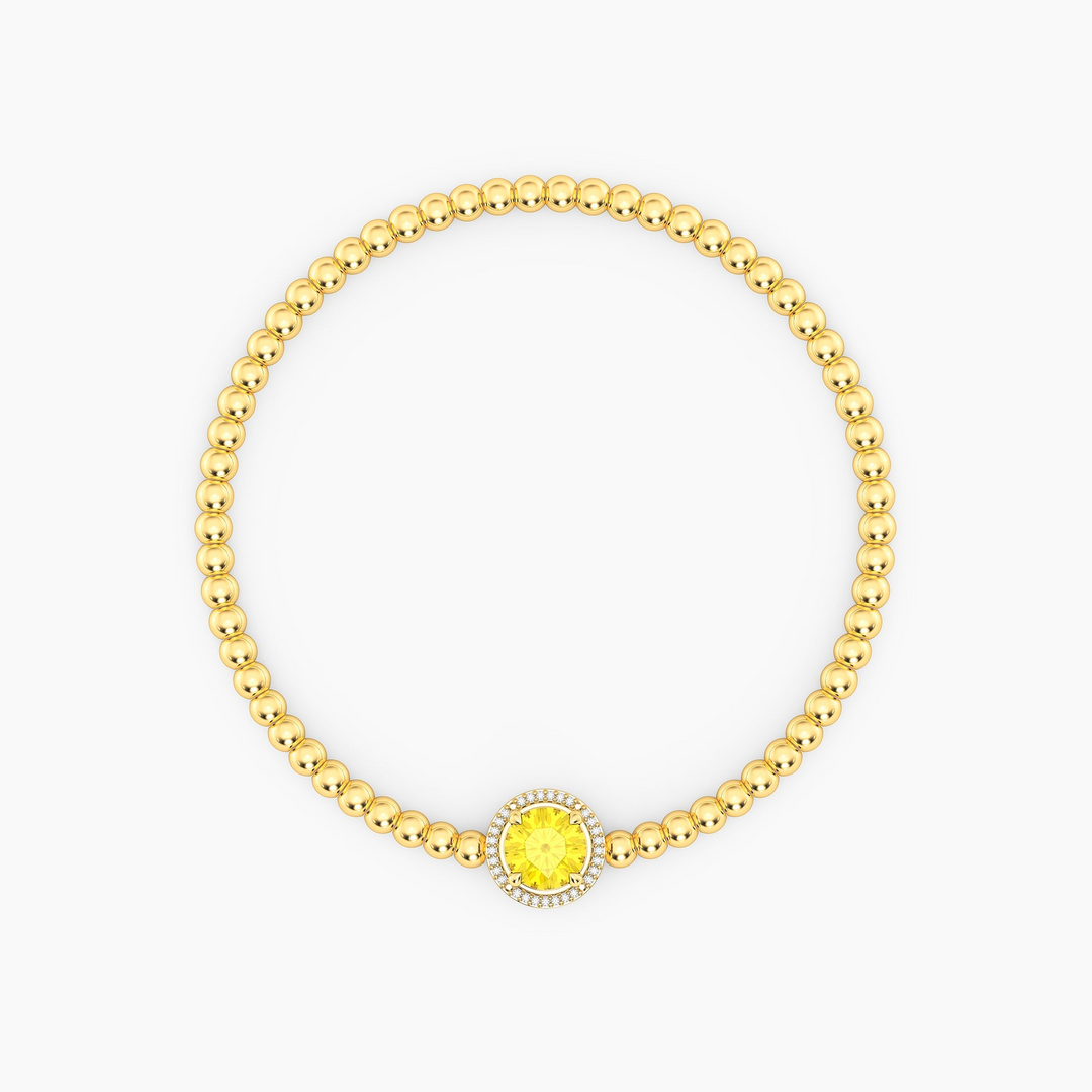 Gold plated beaded bracelet with a round yellow center stone and diamond halo.