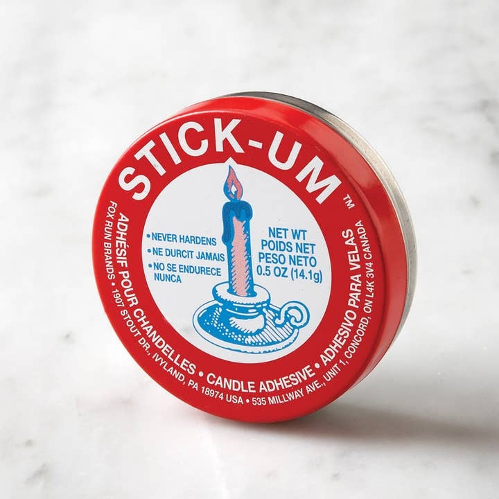 Fox Run Stick-Um Candle Adhesive in a small red and white 0.5-ounce round tin.