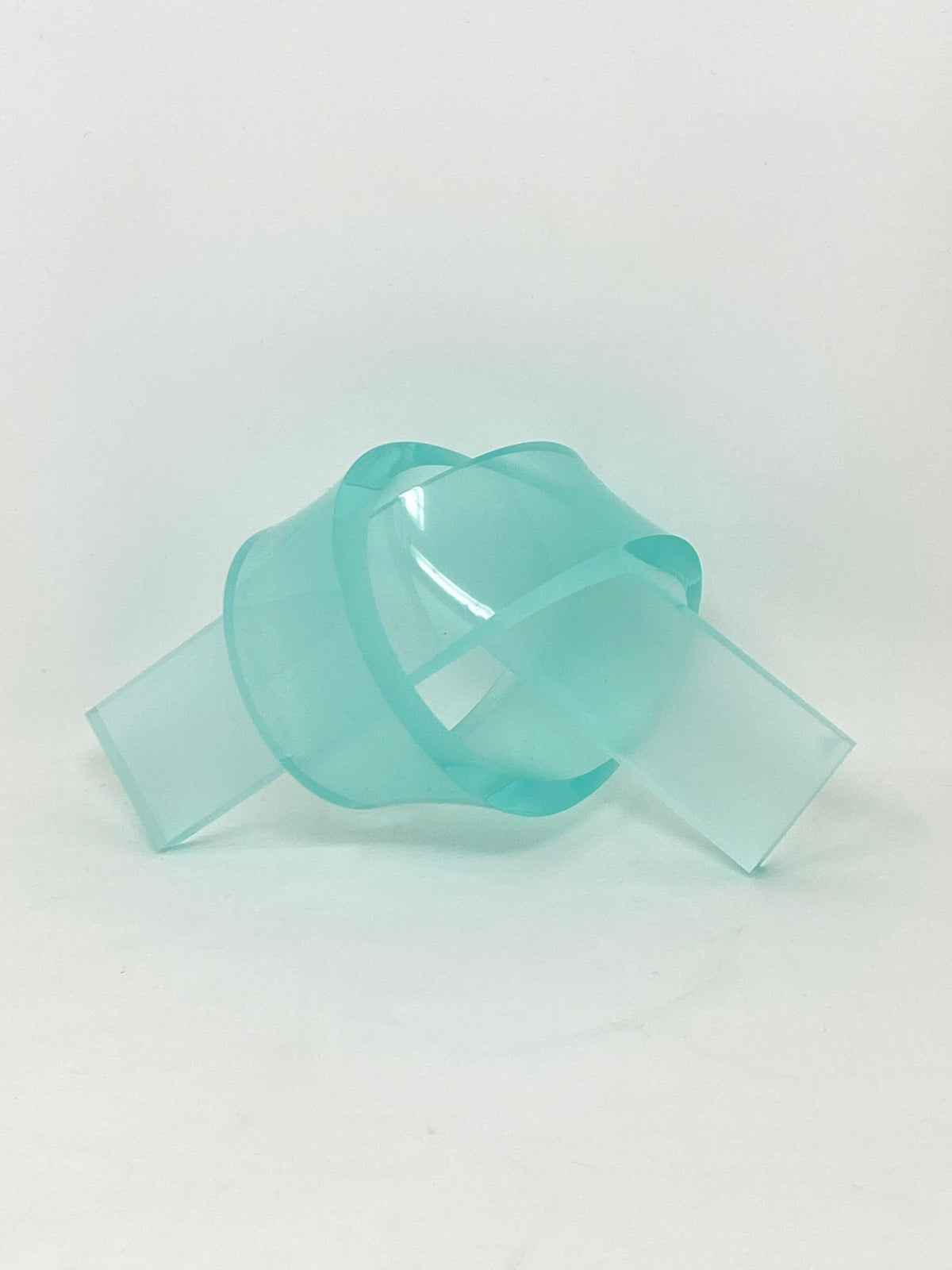 Acrylic knot pendant in clear acrylic with a silver-tone bail.