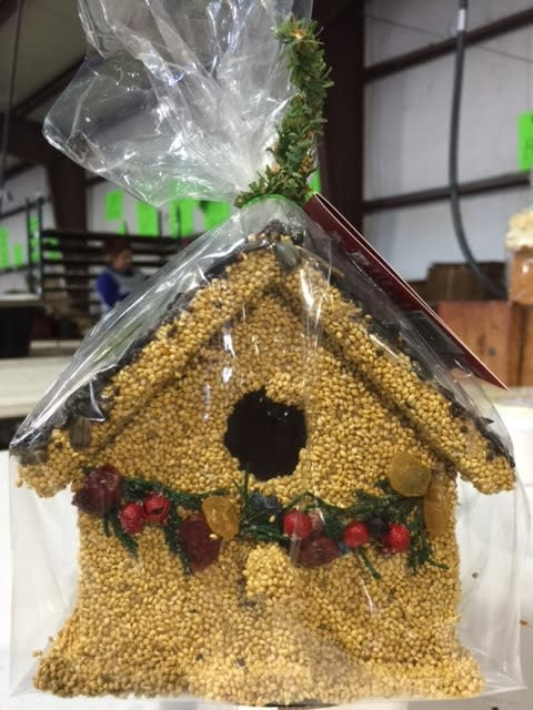 Hand-decorated wooden birdhouse cottage with millet, juniper, cranberries, and raisins.