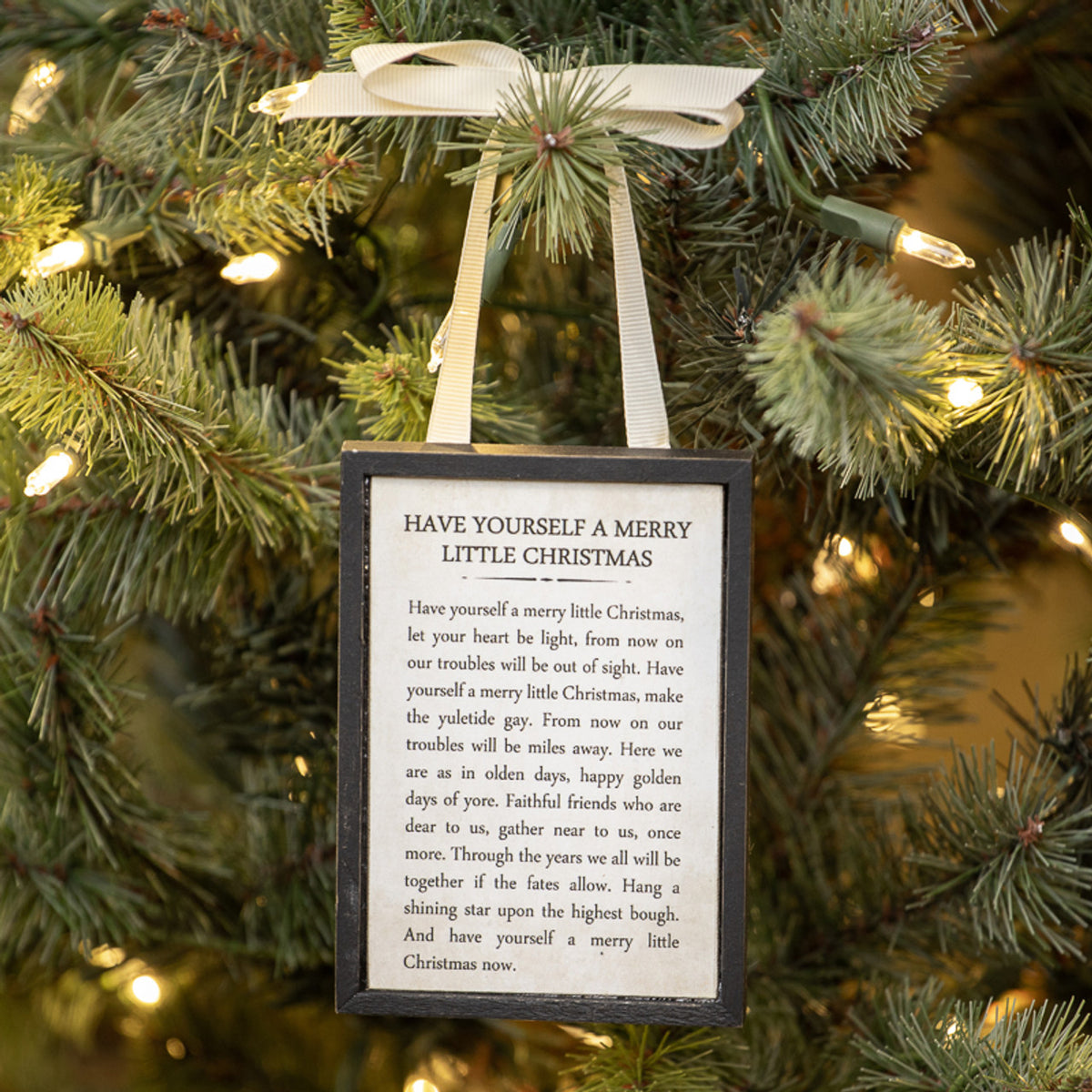 Wooden sign ornament shaped like a lowercase 'j' with white lettering on natural wood grain.