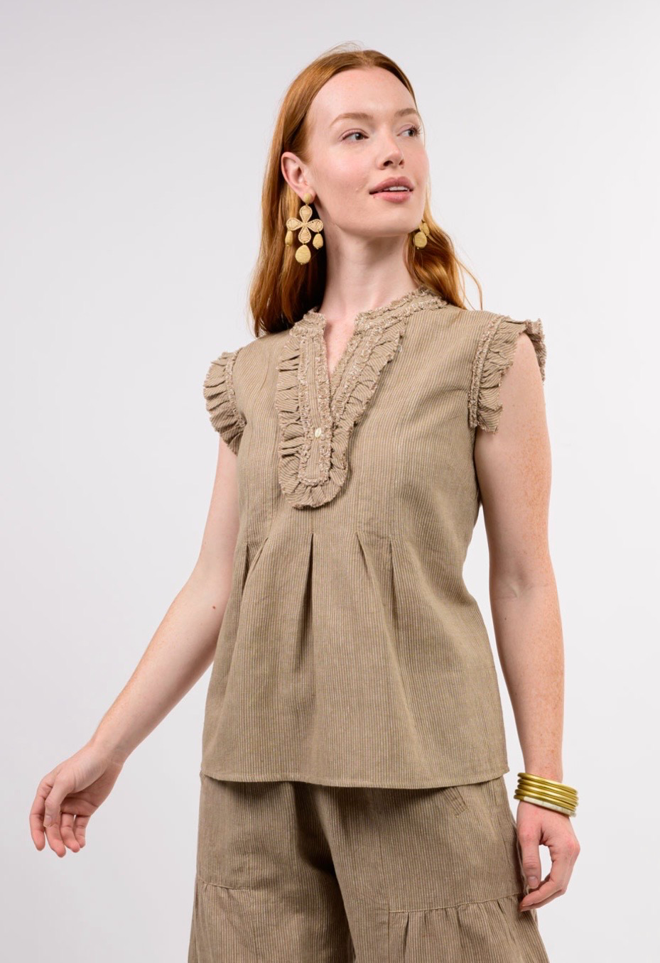 Woman wearing the Angela Striped Ruffle Top in tan with matching shorts and gold accessories.