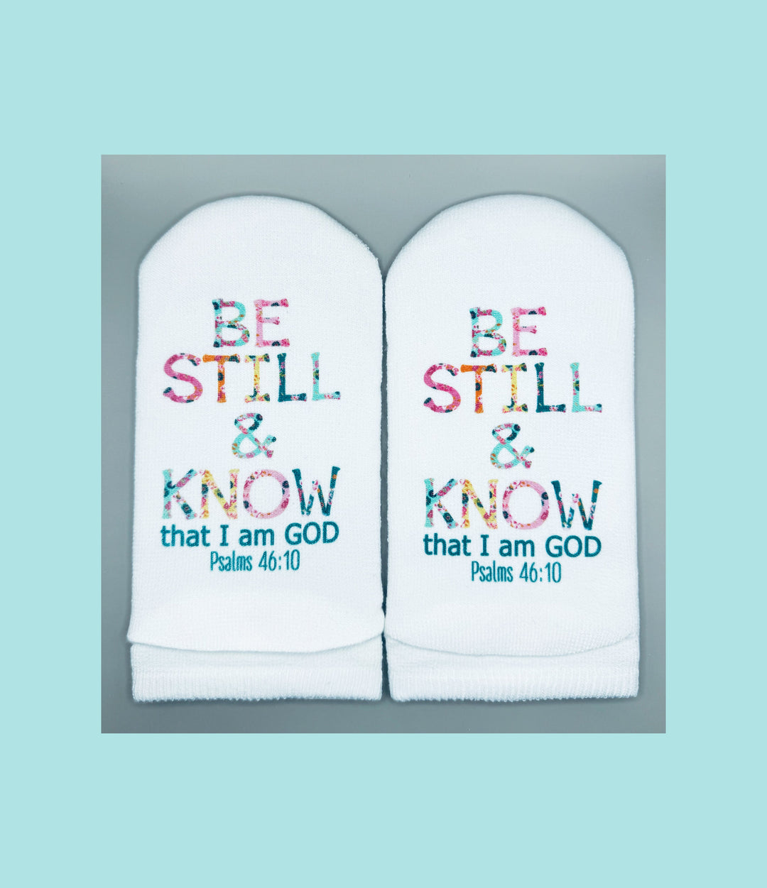 White no-show socks featuring the floral text "BE STILL & KNOW that I am GOD Psalms 46:10".