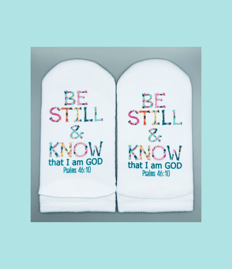 White no-show socks featuring the floral text "BE STILL & KNOW that I am GOD Psalms 46:10".