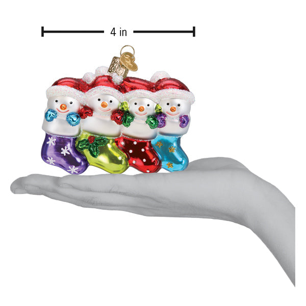 Snow Family of 4 glass ornament held in a hand, measuring 4 inches wide.