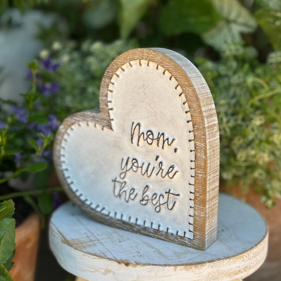 Wooden heart-shaped plaque with carved 'Mom, you're the best' text and stitch-style edging.