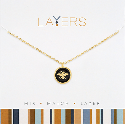 Gold chain necklace with a black circular coin pendant featuring a gold bee design.