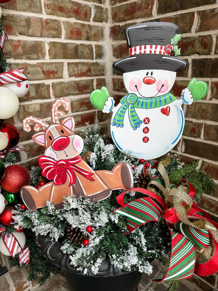Green knit scarf with white snowman motif on a medium-sized display stand