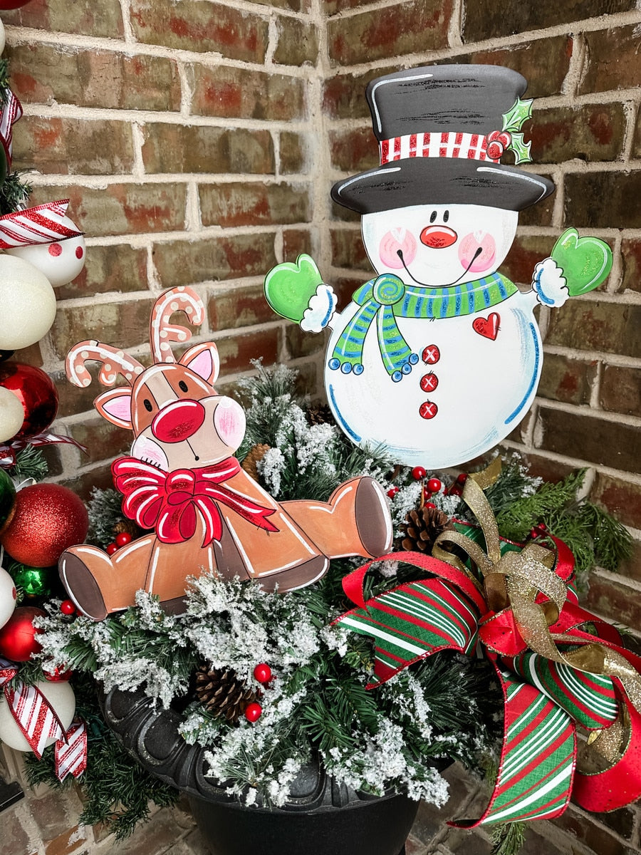 Green knit scarf with white snowman motif on a medium-sized display stand