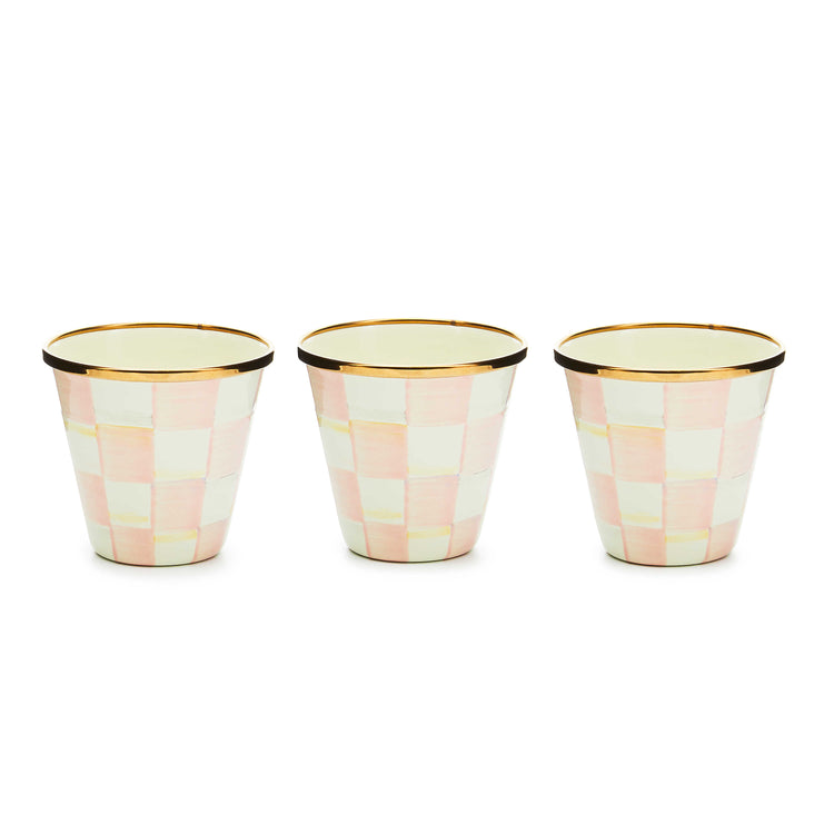 Three hand-painted pink and white checkered herb pots with bronzed stainless steel rims.